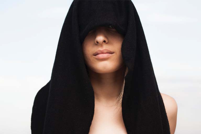 lady with a black cloth covering her hair and eyes