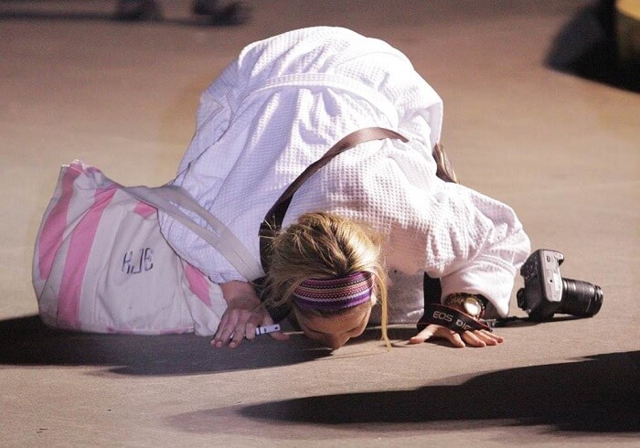 Kendall Jenkins of Houston kisses the ground after stepping off the Carnival ship Triumph