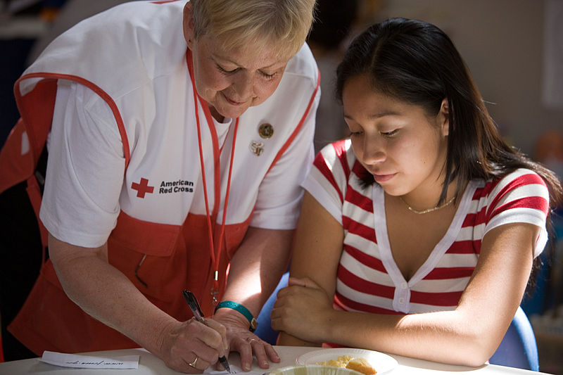 red cross volunteer with disaster victim filling out paperwork