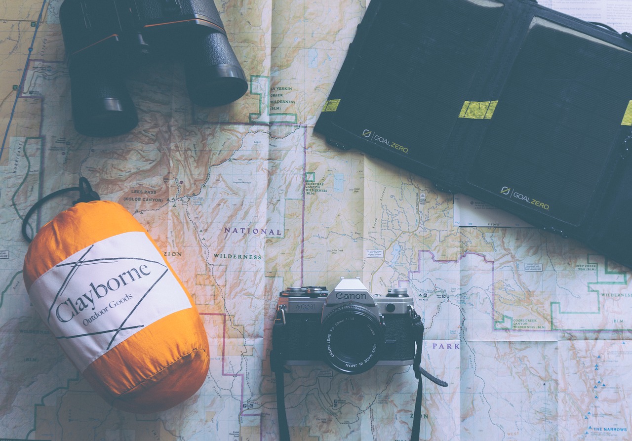 adventure pack with map camera and orange duffle bag