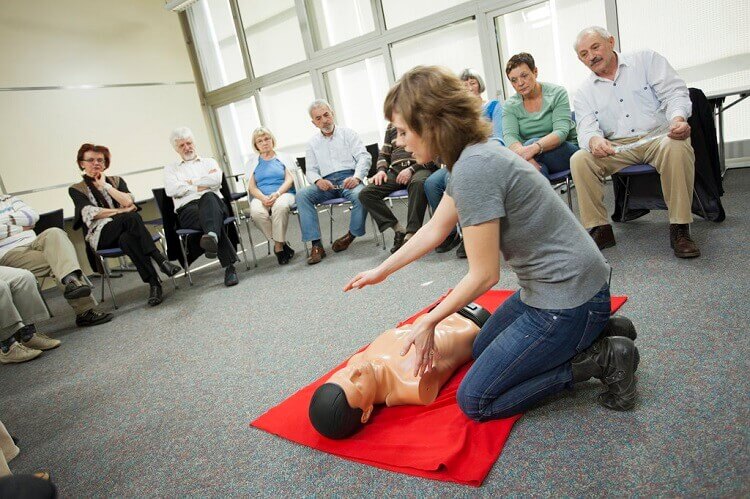 trainer showing the trainees how to do CPR. Medical training is one of the best disaster preparedness tips.
